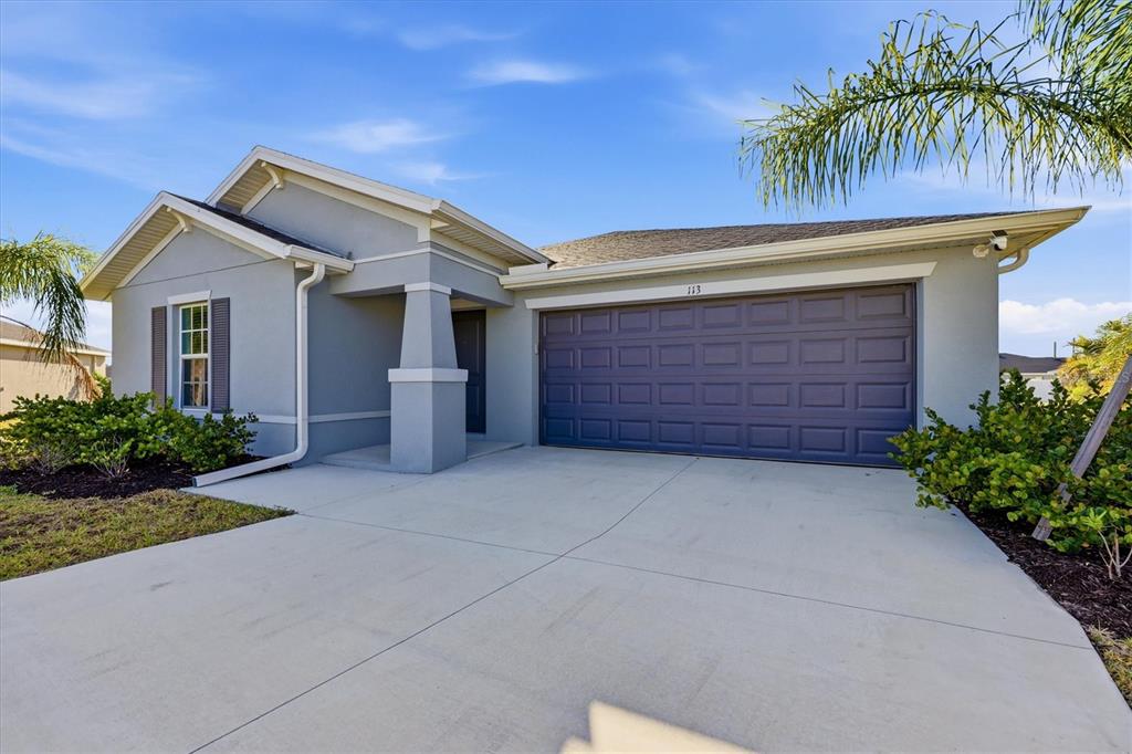 A single-story house with a gray exterior, a two-car garage, and a concrete driveway — 113 LILYAN COURT, ROTONDA WEST, FL