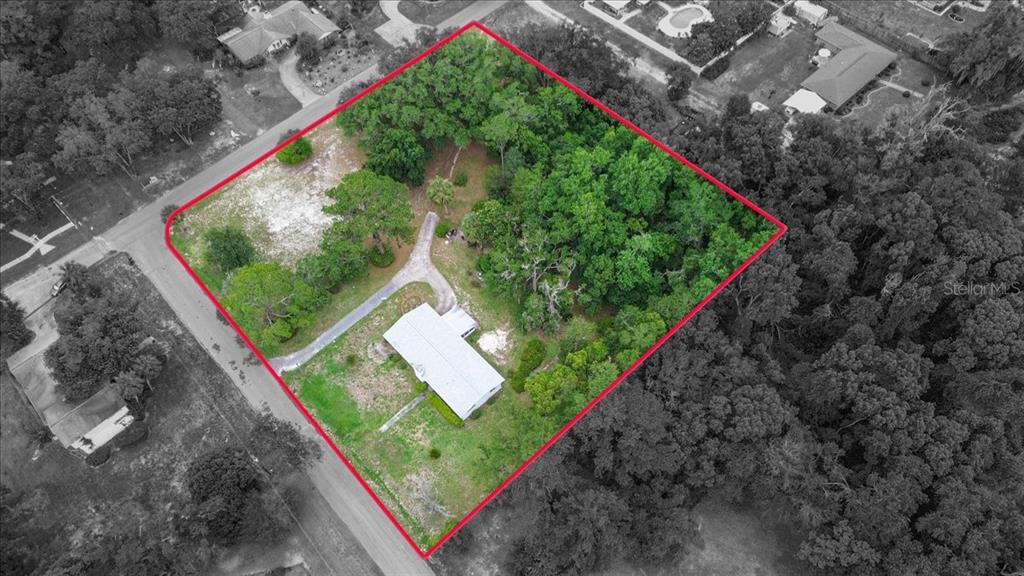 An aerial view shows a house on a large, partially wooded lot outlined in red — 23363 NW 191ST AVENUE, HIGH SPRINGS, FL
