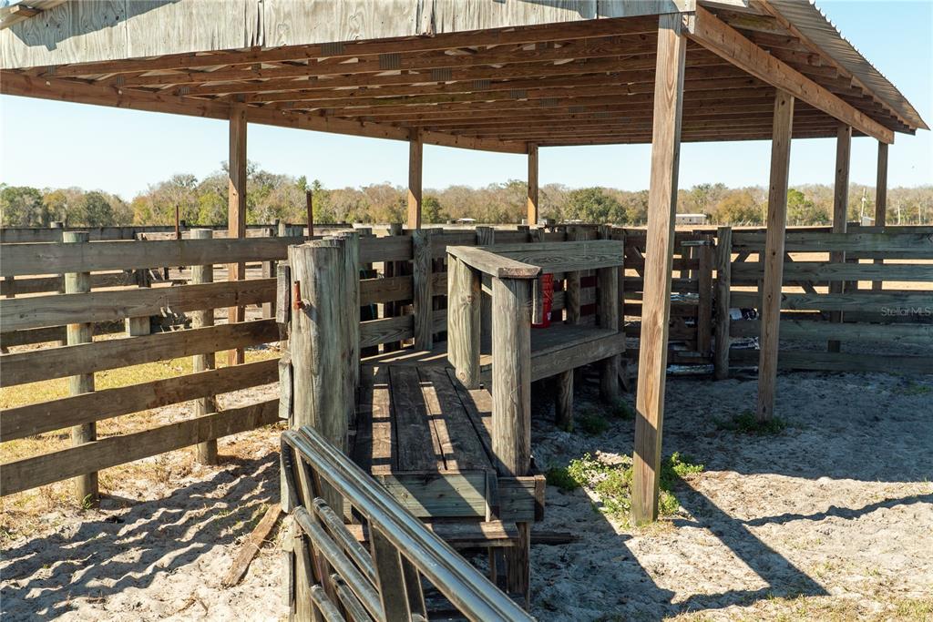 A covered wooden cattle working chute and pen area sits in a sandy outdoor lot — 1200 ARBUCKLE BRANCH ROAD, SEBRING, FL