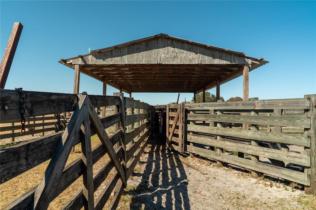 A wooden cattle chute and holding pen are covered by a simple metal-roofed structure — 1200 ARBUCKLE BRANCH ROAD, SEBRING, FL