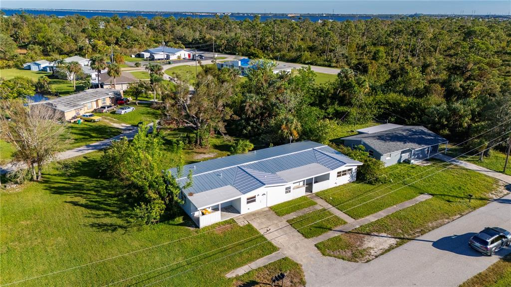 An aerial view shows a single-story house with a metal roof and a concrete driveway — 4362 PINNACLE STREET, PUNTA GORDA, FL