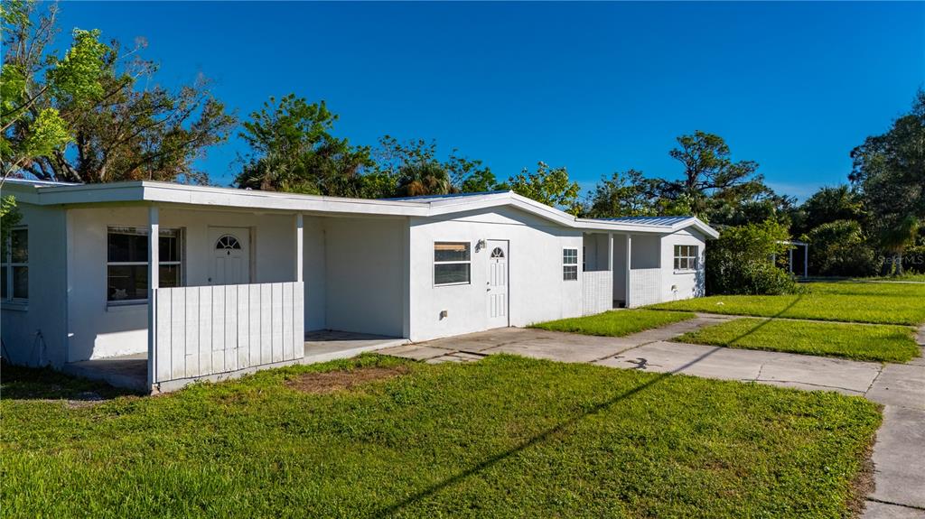 A white, single-story duplex with a flat roof and a concrete driveway sits on grass — 4362 PINNACLE STREET, PUNTA GORDA, FL