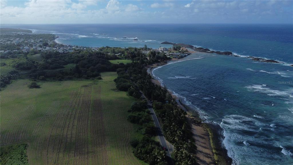 An aerial view shows a coastal landscape with houses nestled among trees near the ocean — Puerto Nuevo ward PR 686 Lot. 9, VEGA BAJA, PR