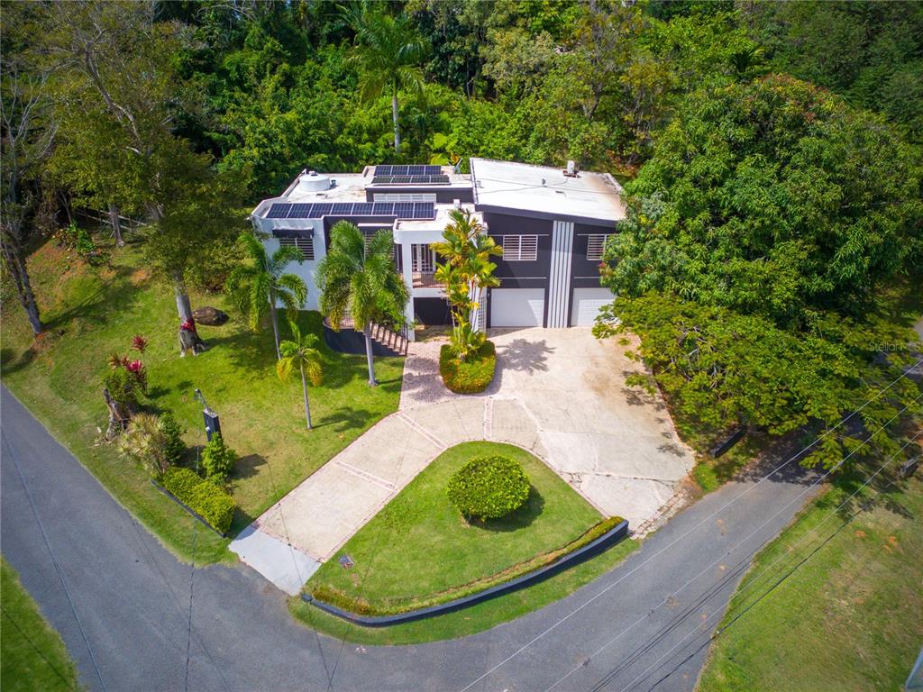 An aerial view of a two-story house with solar panels and a paved driveway — 1 SECTOR LOS CRUZADOS, MAYAGUEZ, PR