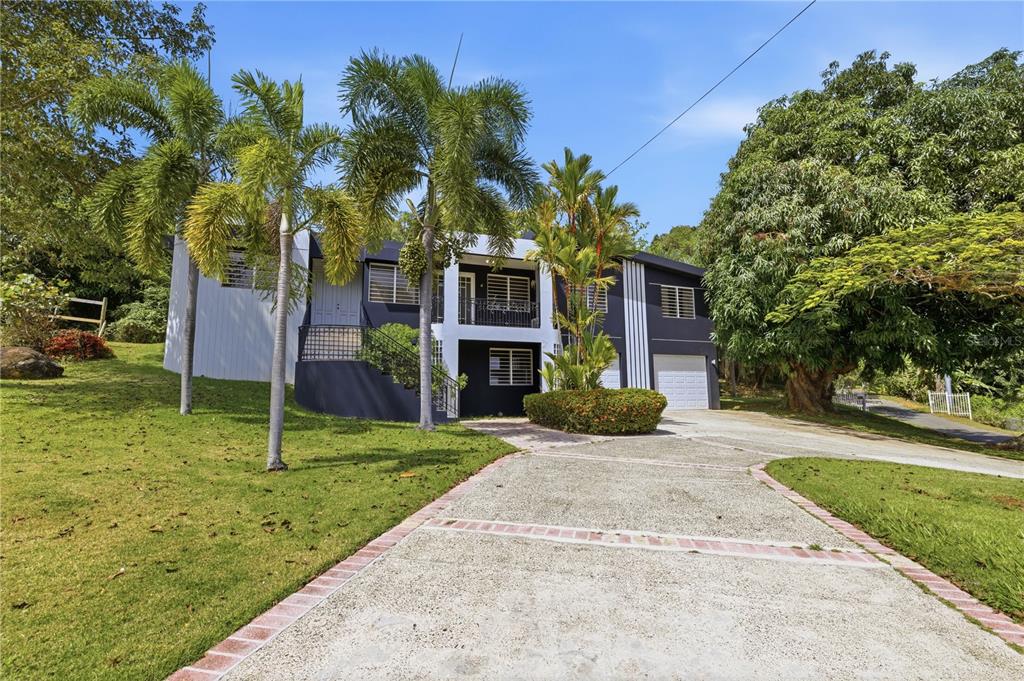 A two-story house with a dark exterior, white trim, and a concrete driveway — 1 SECTOR LOS CRUZADOS, MAYAGUEZ, PR