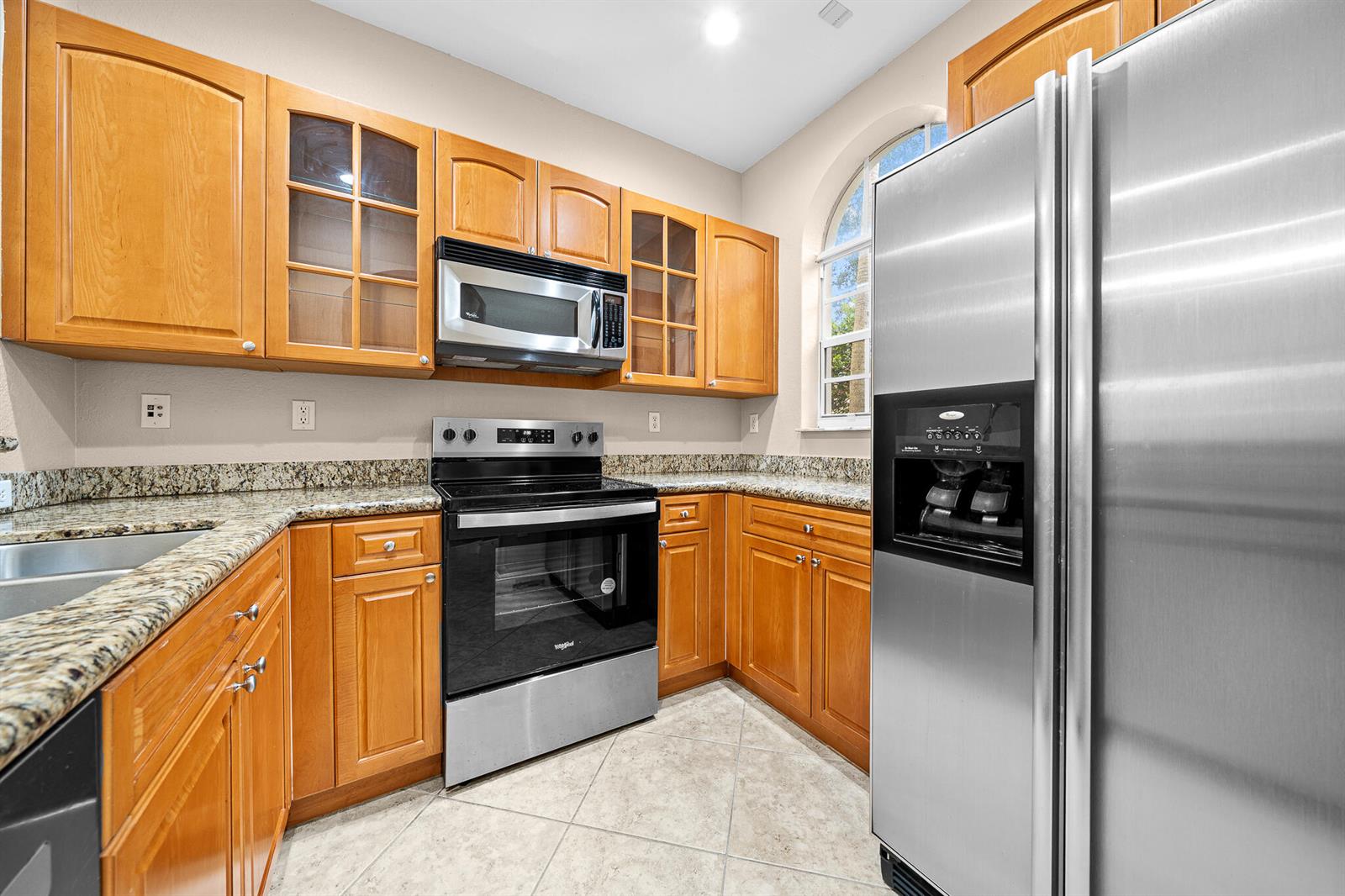 A kitchen features wood cabinets, granite countertops, stainless steel appliances, and a tiled floor — 5100 SW 141st Avenue, Miramar FL 33027, MIRAMAR, FL