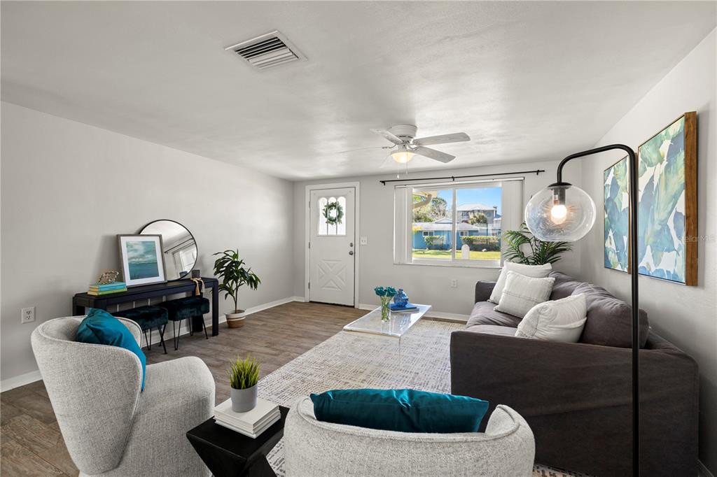 A living room features a grey sofa, two armchairs, a console table, and a front door — 5041 BAY BOULEVARD, PORT RICHEY, FL