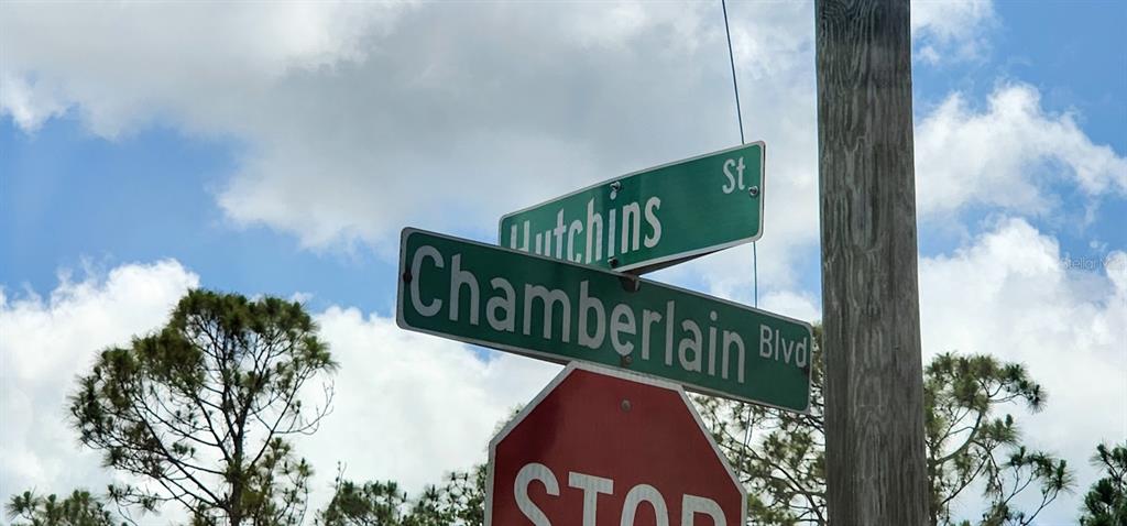 A street sign for Chamberlain Blvd and Hutchins St sits above a stop sign — 436 HUTCHINS STREET, PORT CHARLOTTE, FL