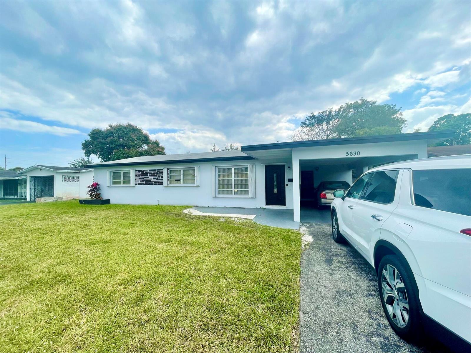 A single-story house with a white exterior, a carport, and a front lawn — 5630 Hollywood Boulevard, Hollywood FL 33021, HOLLYWOOD, FL