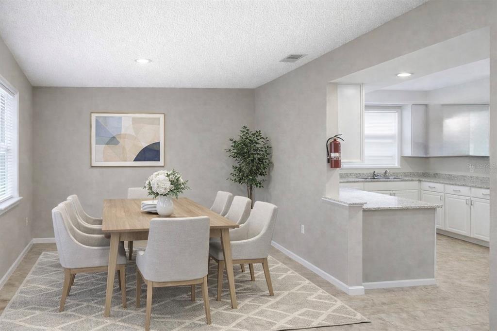 A kitchen with white cabinets, granite countertops, stainless steel appliances, and light-colored tile flooring — 416 BANANA CAY DRIVE UNIT D, SOUTH DAYTONA, FL