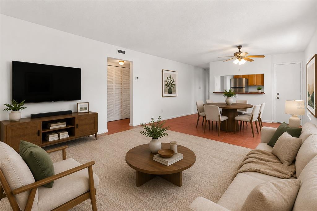 A living room and dining area with white walls, tile flooring, and neutral-toned furniture — 1000 S SEMORAN BOULEVARD UNIT 302, WINTER PARK, FL