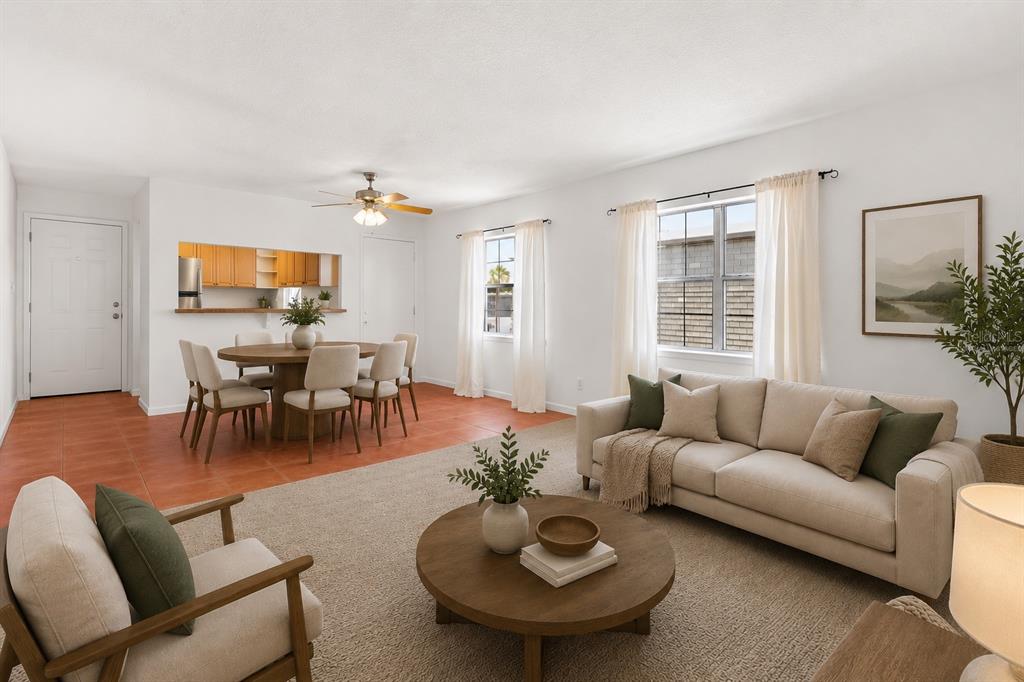 A living and dining area with tile and carpet flooring, a sofa, and a round table — 1000 S SEMORAN BOULEVARD UNIT 302, WINTER PARK, FL