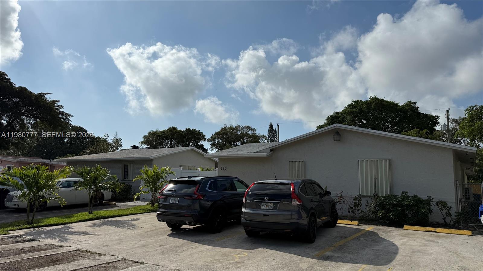 Two dark SUVs are parked in front of a single-story building with a concrete driveway — 216 NW 12th St, Pompano Beach FL 33060, POMPANO BEACH, FL
