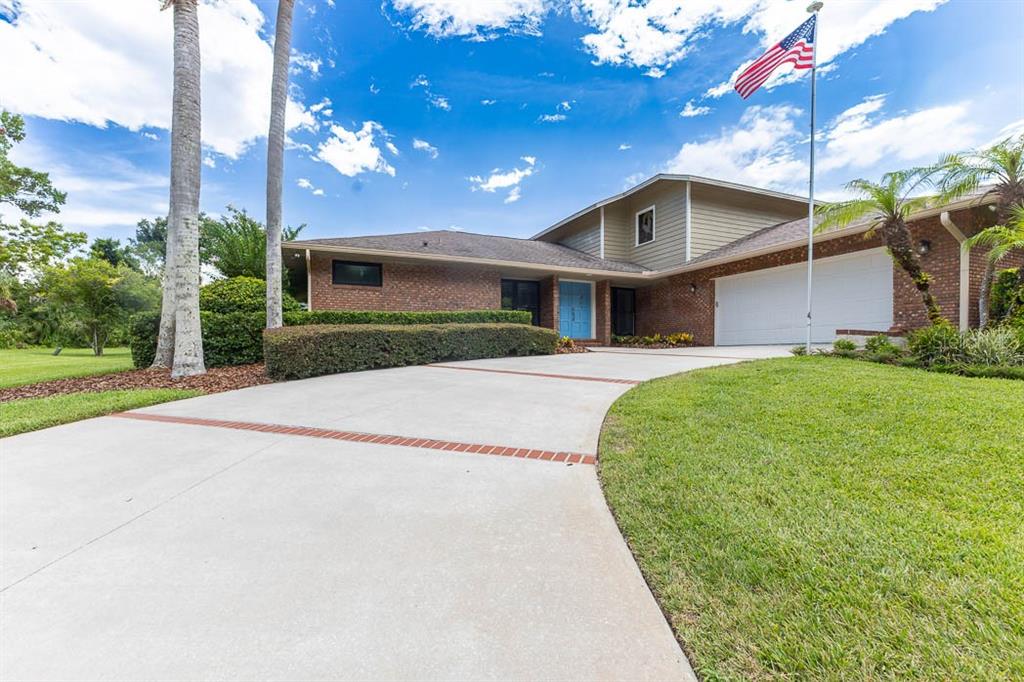 A brick and siding house with a concrete driveway and an American flag — 403 TIMBER RIDGE DRIVE, LONGWOOD, FL