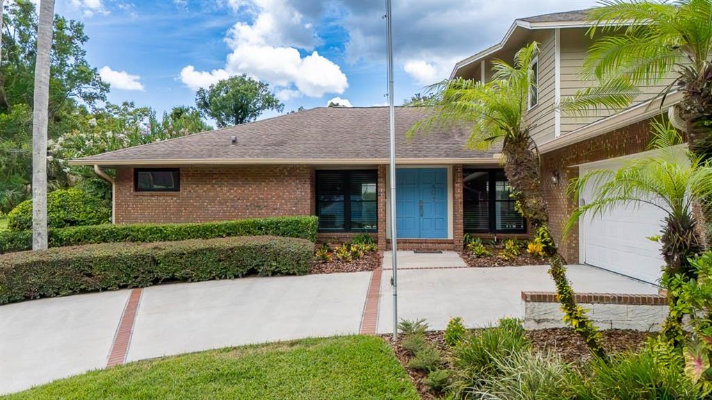 A brick house with a blue double front door and a concrete driveway — 403 TIMBER RIDGE DRIVE, LONGWOOD, FL