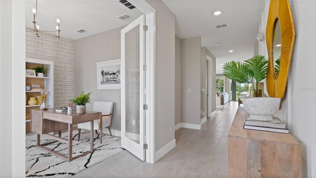 A home office with a desk and rug sits beside a hallway with tile flooring — 30237 RUSTIC MILL STREET, MOUNT DORA, FL