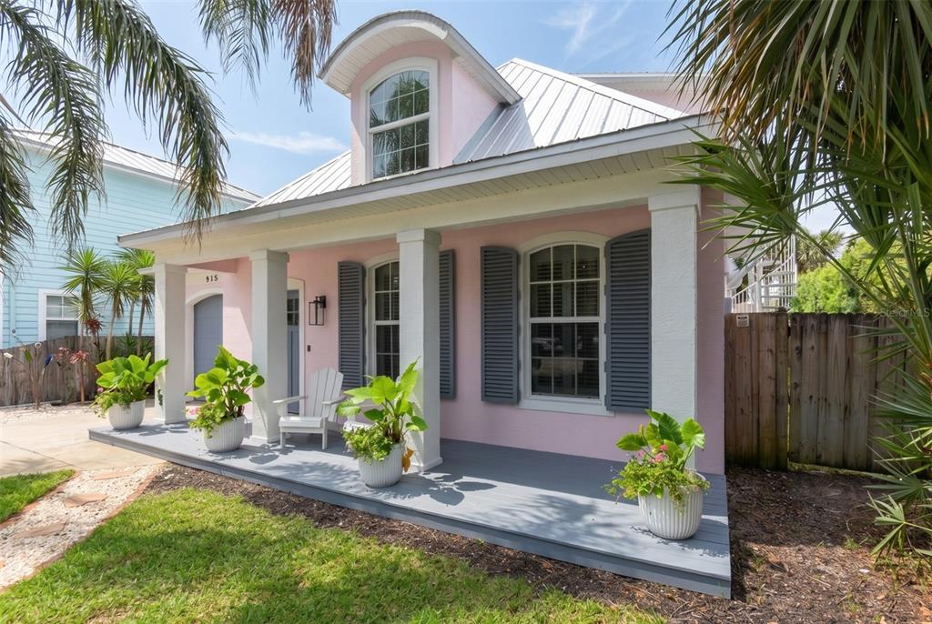 A pink house with a pool, patio furniture, and a fire pit at night — 915 MAPLE STREET, NEW SMYRNA BEACH, FL