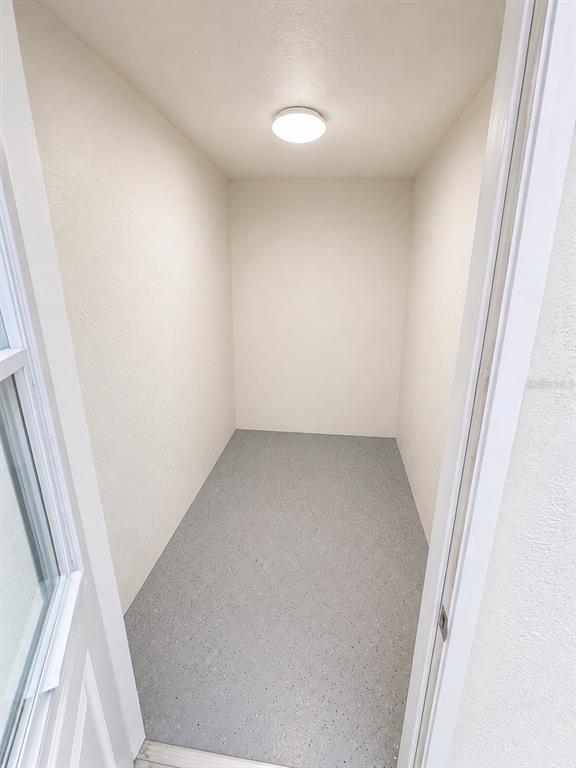 A small, empty storage closet with white walls, a gray speckled floor, and a ceiling light — 3029-3029 WALNUT COURT, LEESBURG, FL