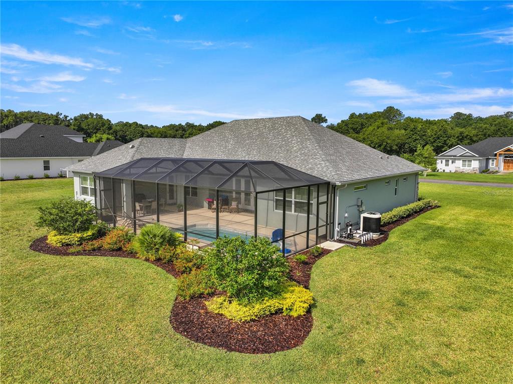 An aerial view of a house with a screened-in pool and a large grassy backyard — 7835 SE 22ND TERRACE, OCALA, FL