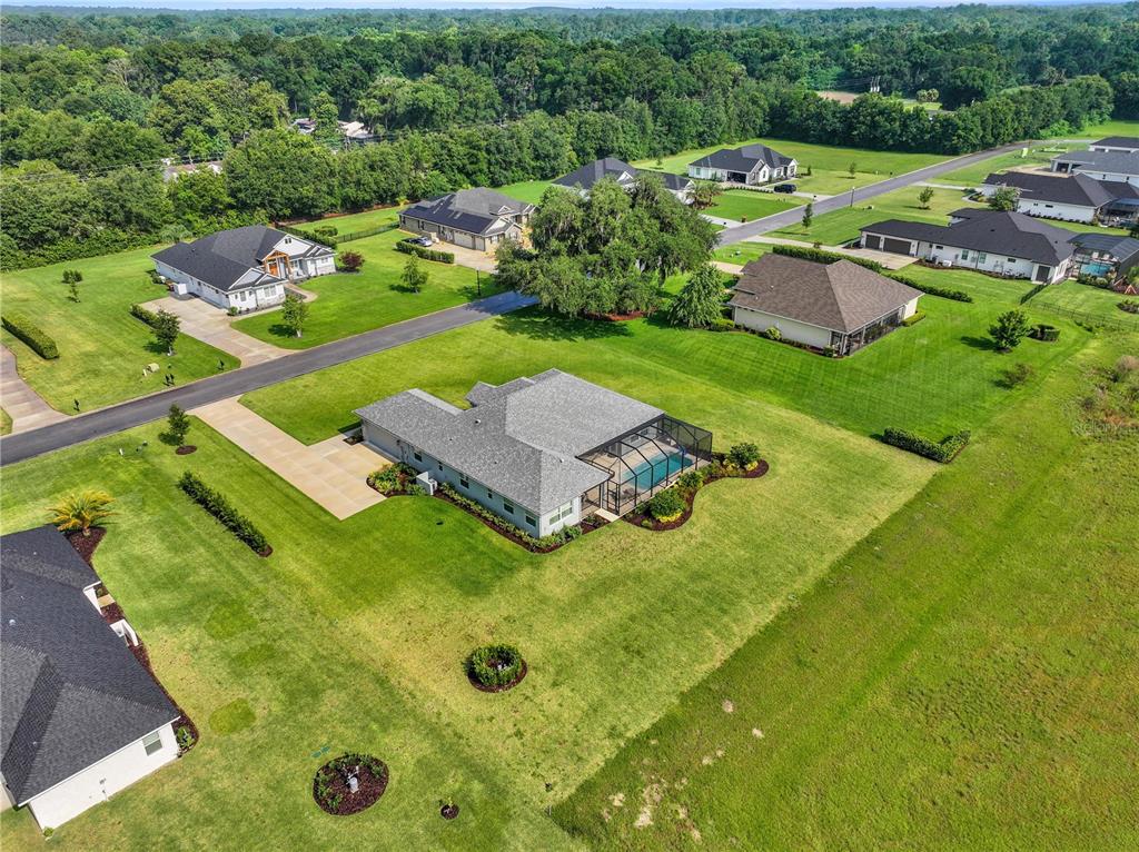 An aerial view shows several suburban houses with swimming pools and large green lawns — 7835 SE 22ND TERRACE, OCALA, FL