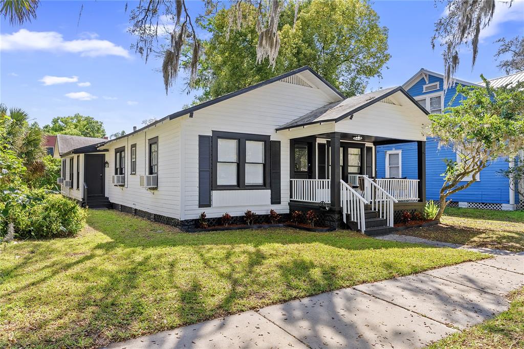 A white, single-story house with black trim and a front porch sits on a lawn — 412 E HARWOOD STREET UNIT 2, ORLANDO, FL
