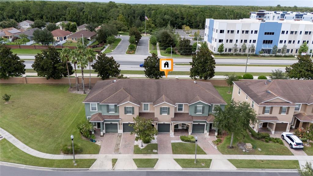 An aerial view shows a multi-unit townhouse building with a brown roof and driveways — 10709 SAVANNAH LANDING CIRCLE, ORLANDO, FL