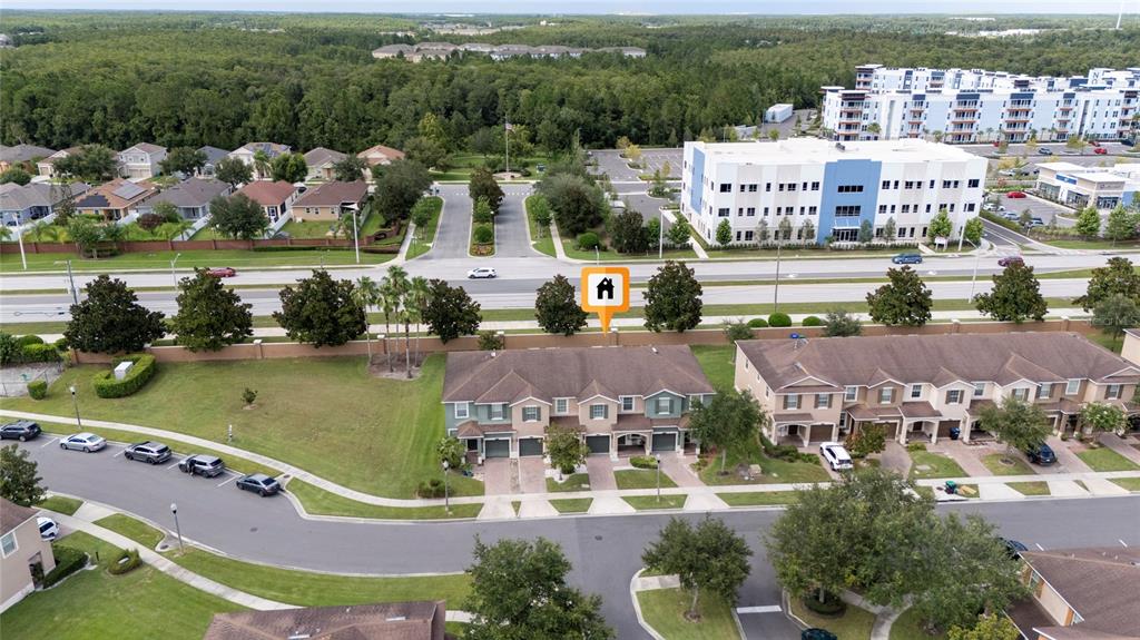 An aerial view shows a row of townhouses with a marked unit and nearby buildings — 10709 SAVANNAH LANDING CIRCLE, ORLANDO, FL