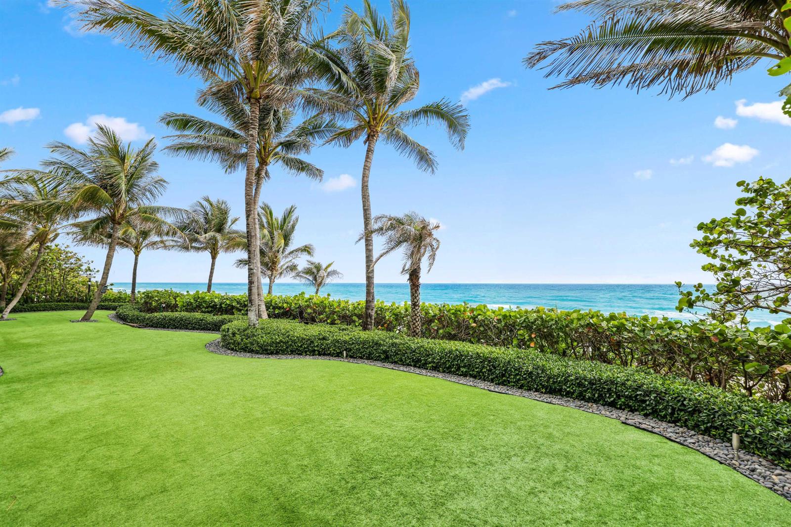 A manicured lawn with palm trees overlooks the ocean behind a trimmed hedge — 3715 S Ocean Boulevard, Highland Beach FL 33487, HIGHLAND BEACH, FL
