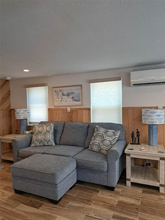 A living room features a gray sofa, matching ottoman, and two side tables with lamps — 2802 PASS A GRILLE WAY UNIT 1, ST PETERSBURG, FL