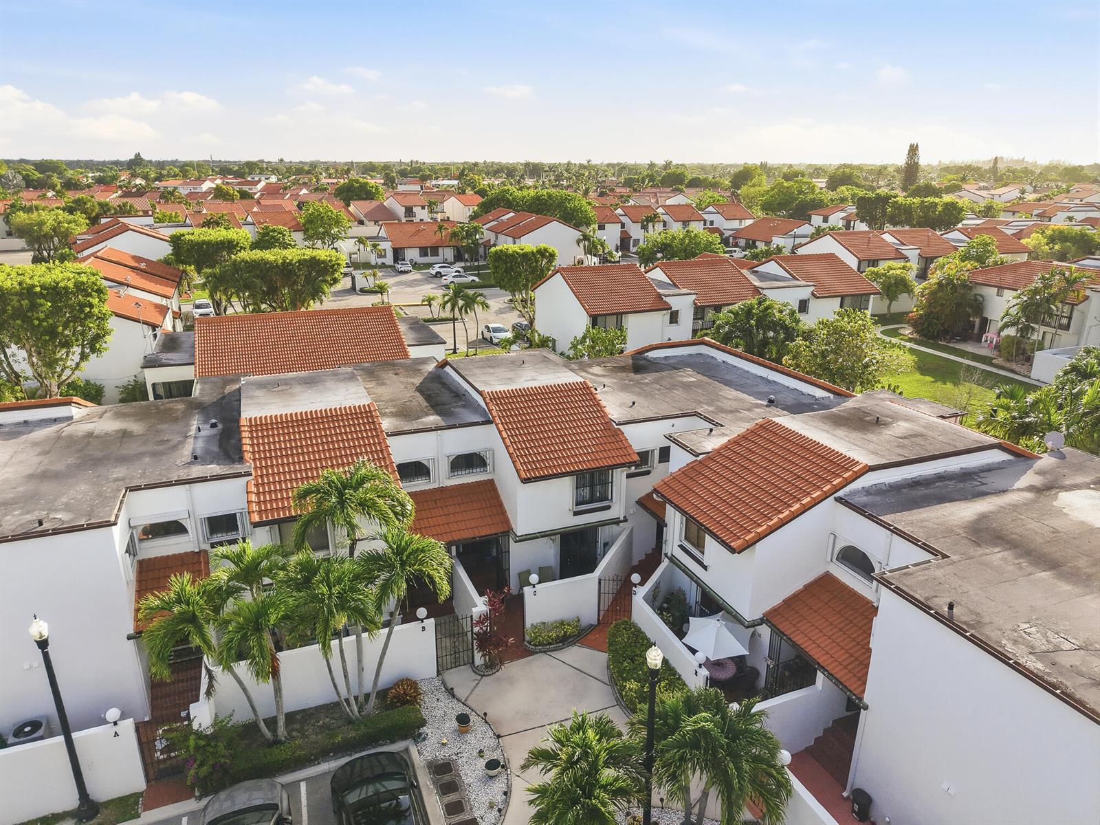 An aerial view shows a cluster of white townhouses with red tile roofs and palm trees — 1461 SW 124th Court # c, Miami FL 33184, MIAMI, FL