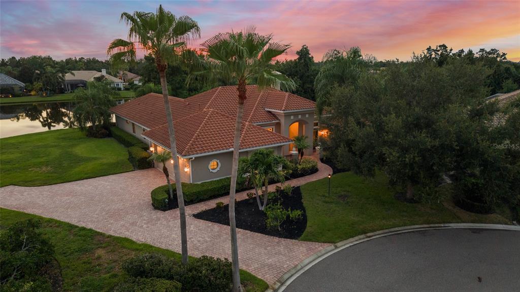 An aerial view of a single-story house with a tile roof and brick paver driveway — 7808 DERBY CT, LAKEWOOD RANCH, FL