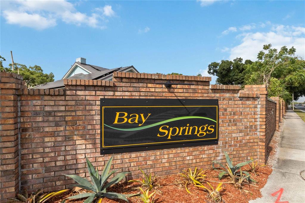 A brick wall displays a sign for Bay Springs under a blue sky — 7524 QUAIL RUN COURT, ORLANDO, FL