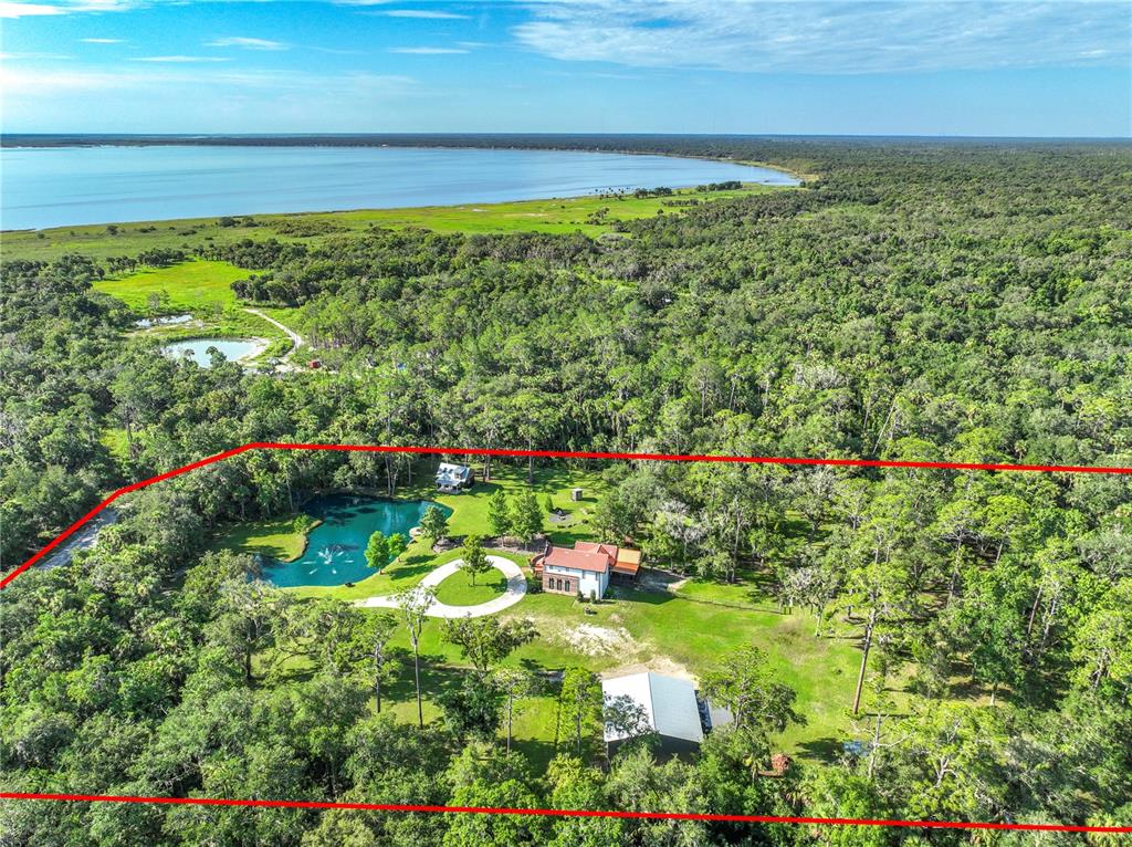 An aerial view shows a house, a pond with a fountain, and a detached building — 2291 WACCASSA STREET, GENEVA, FL