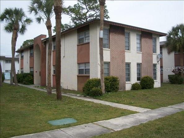 A two-story apartment building with brick and stucco siding stands on a grassy lot — 463 76TH AVENUE N UNIT 3, ST PETERSBURG, FL