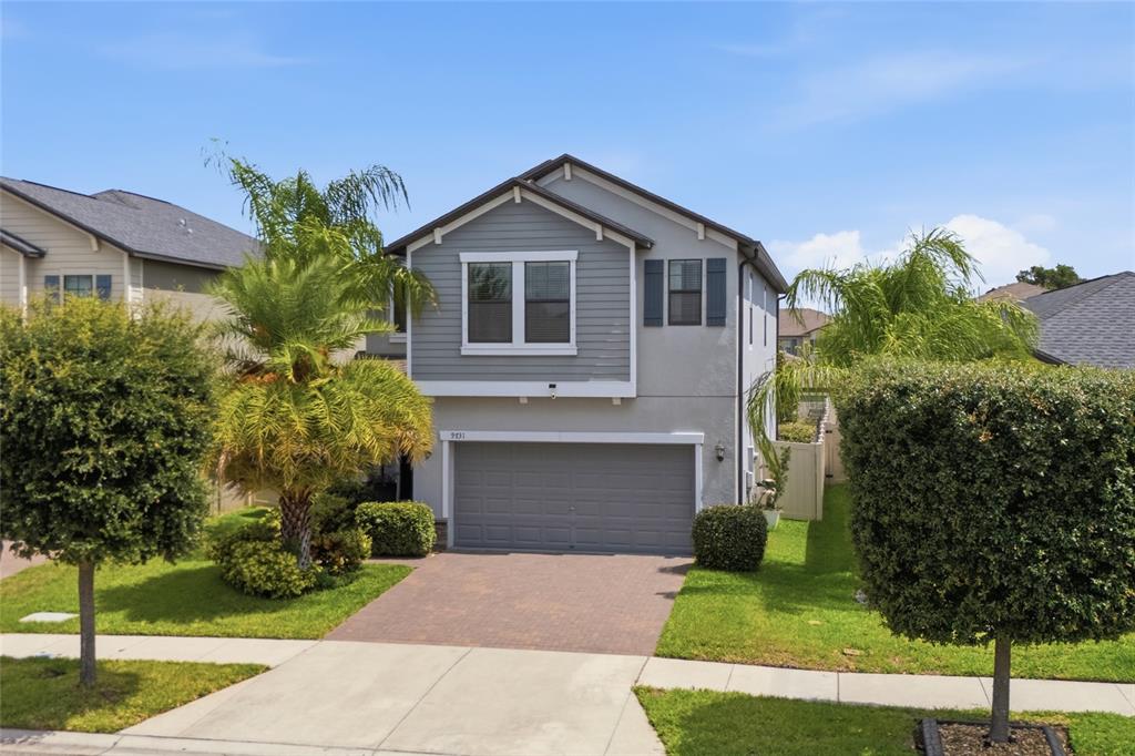 A two-story house with a gray garage, lap siding, and a paved driveway — 9731 IVORY DR, RUSKIN, FL