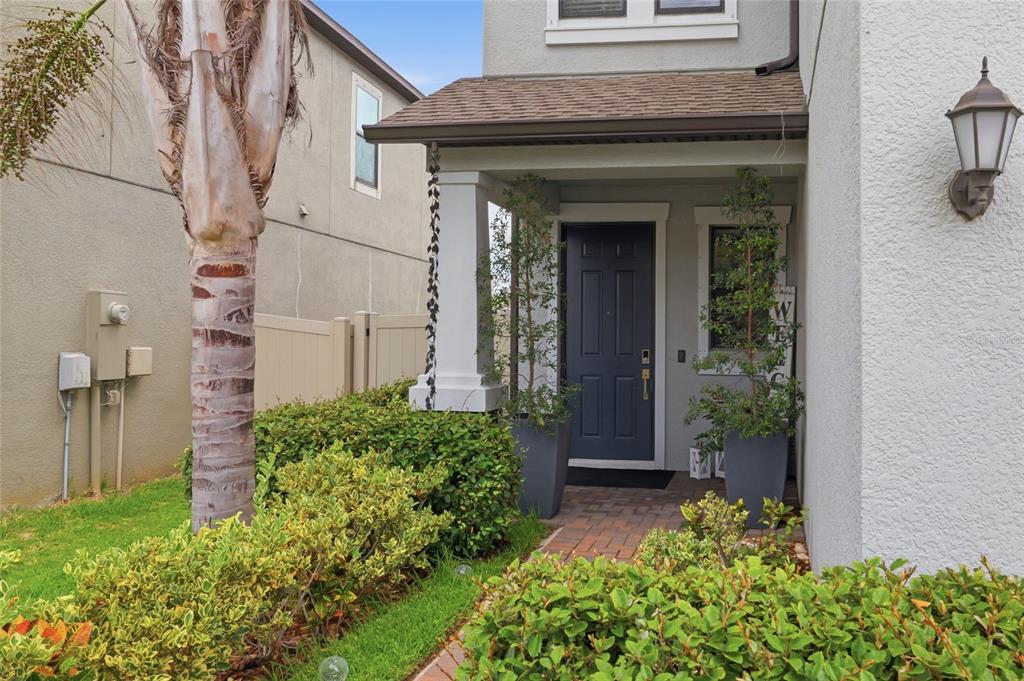 A dark blue front door is framed by two tall planters under a covered entryway — 9731 IVORY DR, RUSKIN, FL