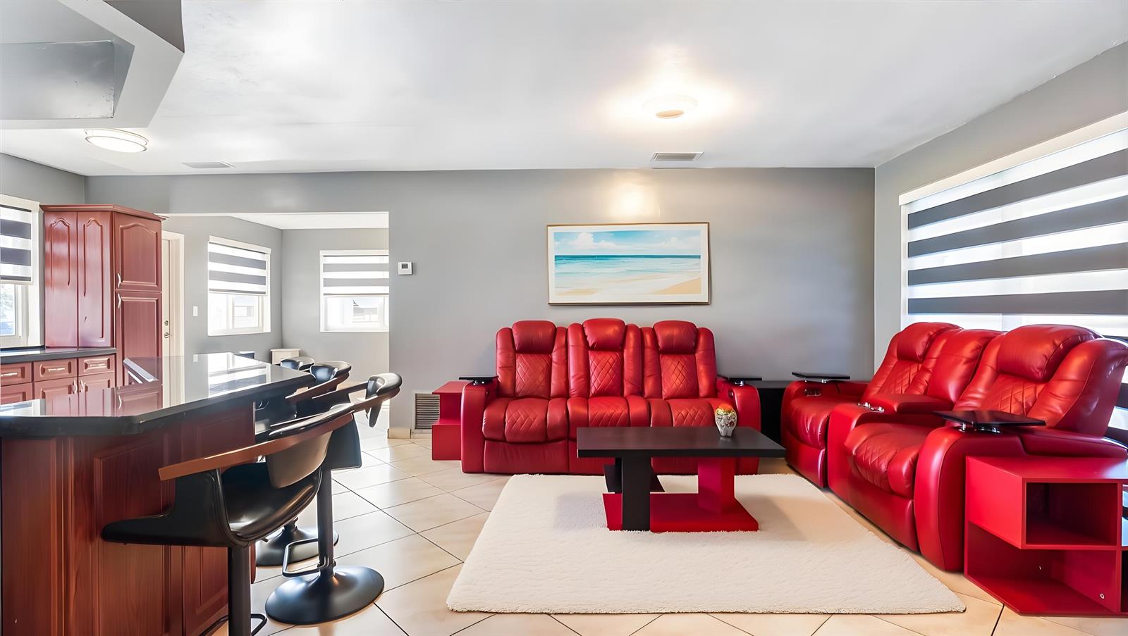 A living room with red leather recliners, a coffee table, and a kitchen island — 3140 Sheridan Lane, Hollywood FL 33021, HOLLYWOOD, FL