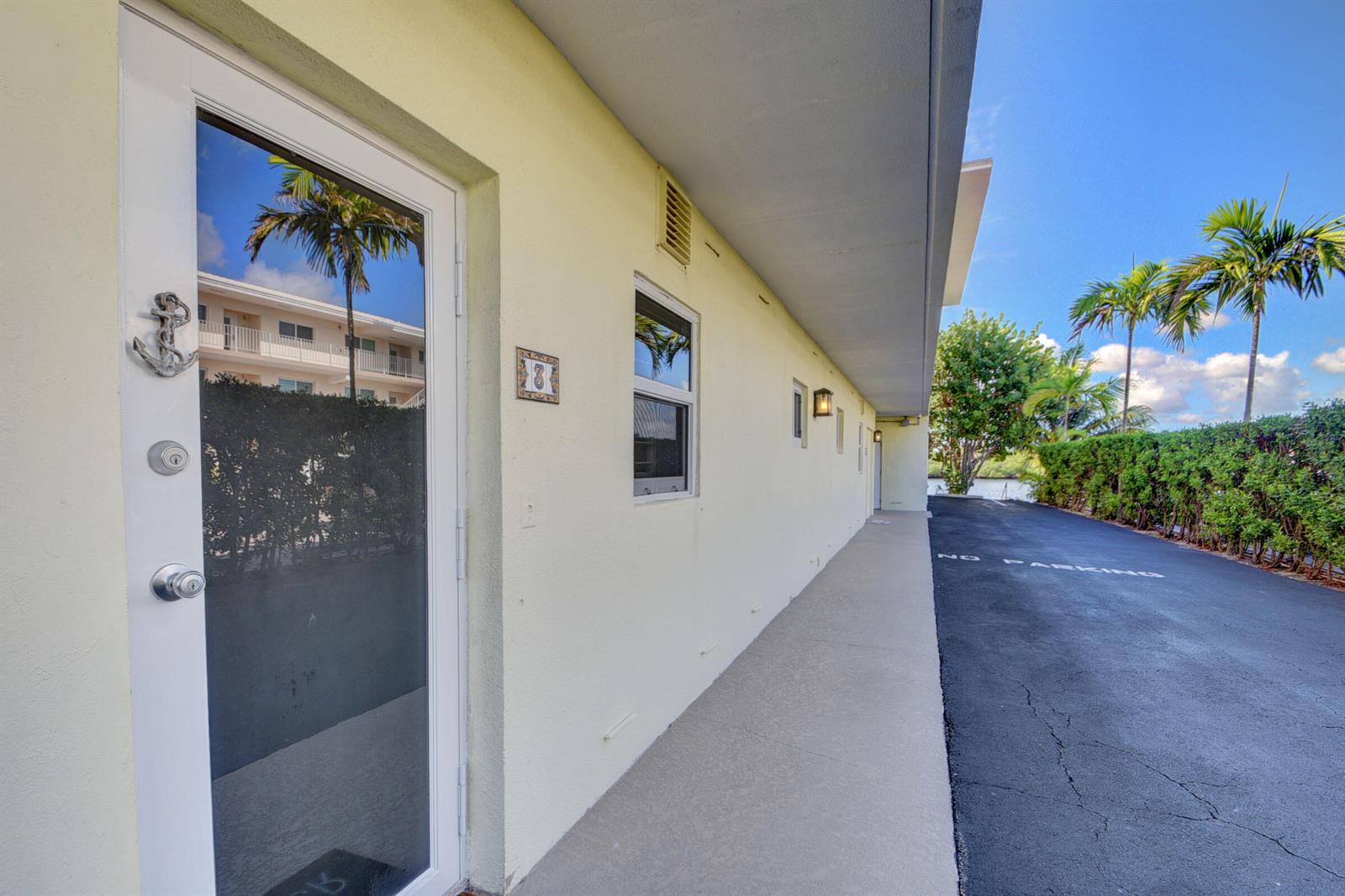 An exterior view of a building with a white door, a window, and a walkway — 6520 N Ocean Boulevard # 3, Ocean Ridge FL 33435, OCEAN RIDGE, FL