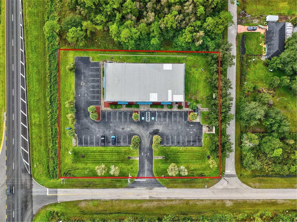 An aerial view shows a commercial building with a parking lot outlined in red — 29291 TRIBUNE BOULEVARD UNIT 4-109, PUNTA GORDA, FL