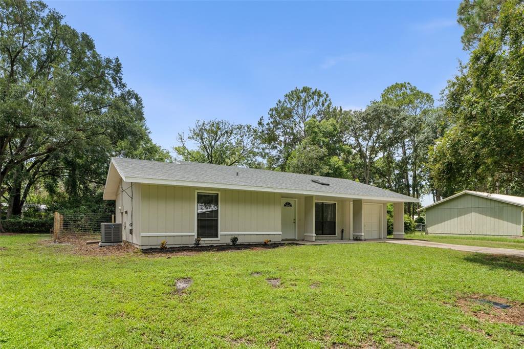 A single-story house with light-colored siding, a shingled roof, and a grassy front yard — 2329 NW 54TH PLACE, GAINESVILLE, FL