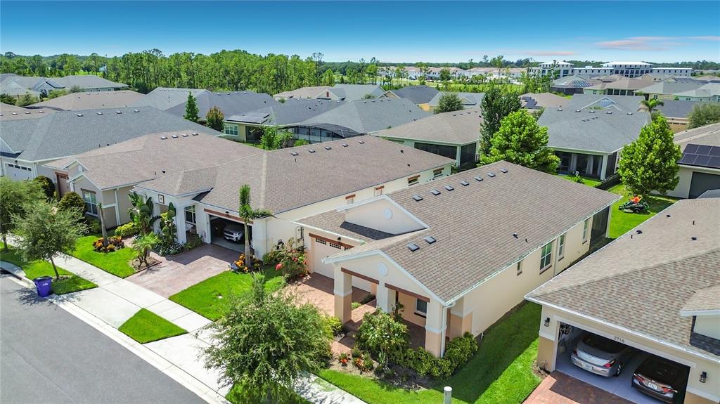 An aerial view shows several suburban houses with brown roofs and attached garages — 2720 GREENLANDS STREET, ST CLOUD, FL