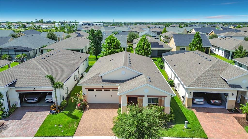 An aerial view shows three suburban houses with paved driveways and green lawns — 2720 GREENLANDS STREET, ST CLOUD, FL