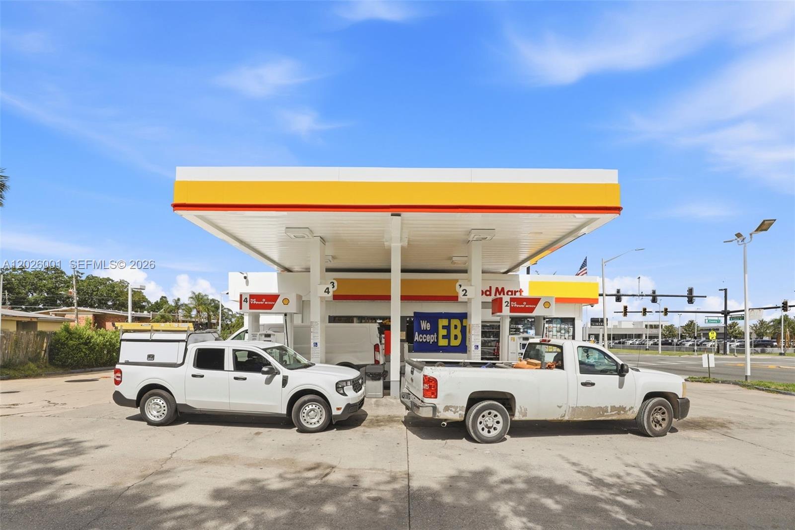 A Shell gas station with a canopy and two white pickup trucks parked underneath — 1916 W COLONIAL DR, Orlando FL 32804, ORLANDO, FL