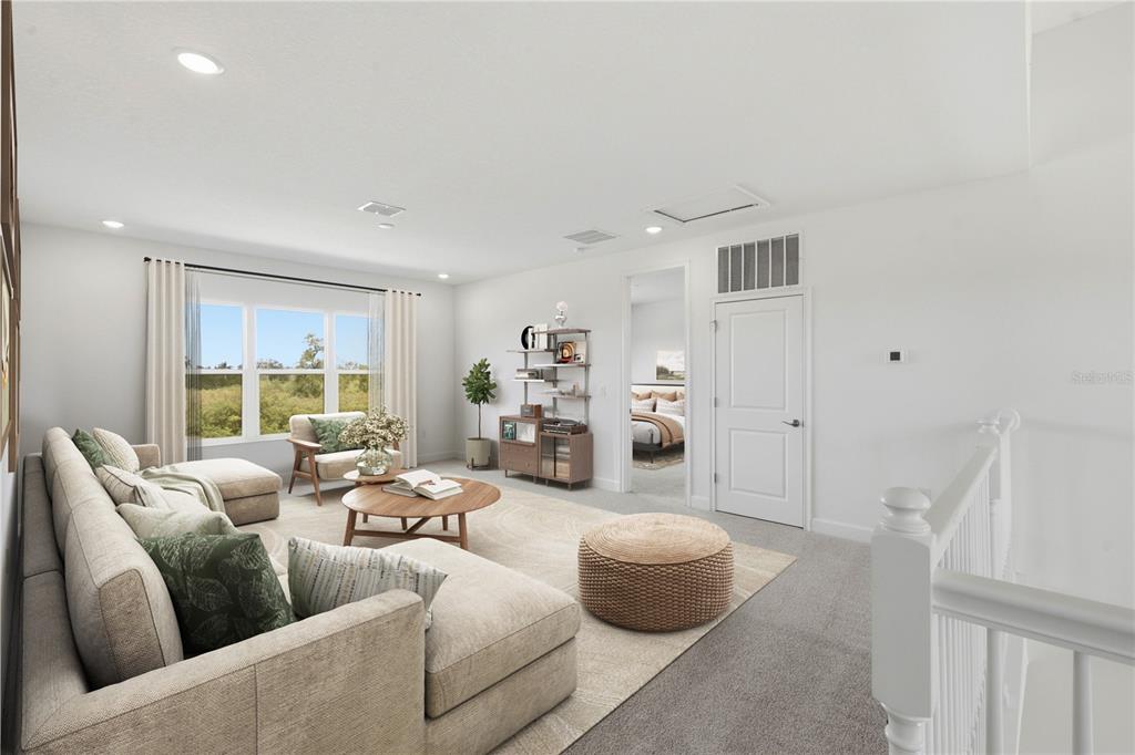 A bright living room features a sectional sofa, a round coffee table, and carpeted flooring — 1031 SIGNET, APOLLO BEACH, FL