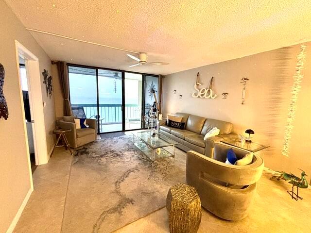 A living room features a sofa, armchairs, glass coffee table, and a balcony with ocean views — 9940 S Ocean Drive # 1004, Jensen Beach FL 34957, JENSEN BEACH, FL