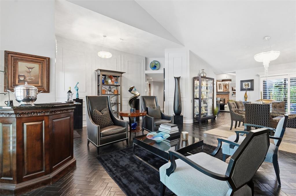 A formal living room features dark hardwood floors, a bar, and modern seating arrangements — 11760 ASHLEY COURT, SEMINOLE, FL