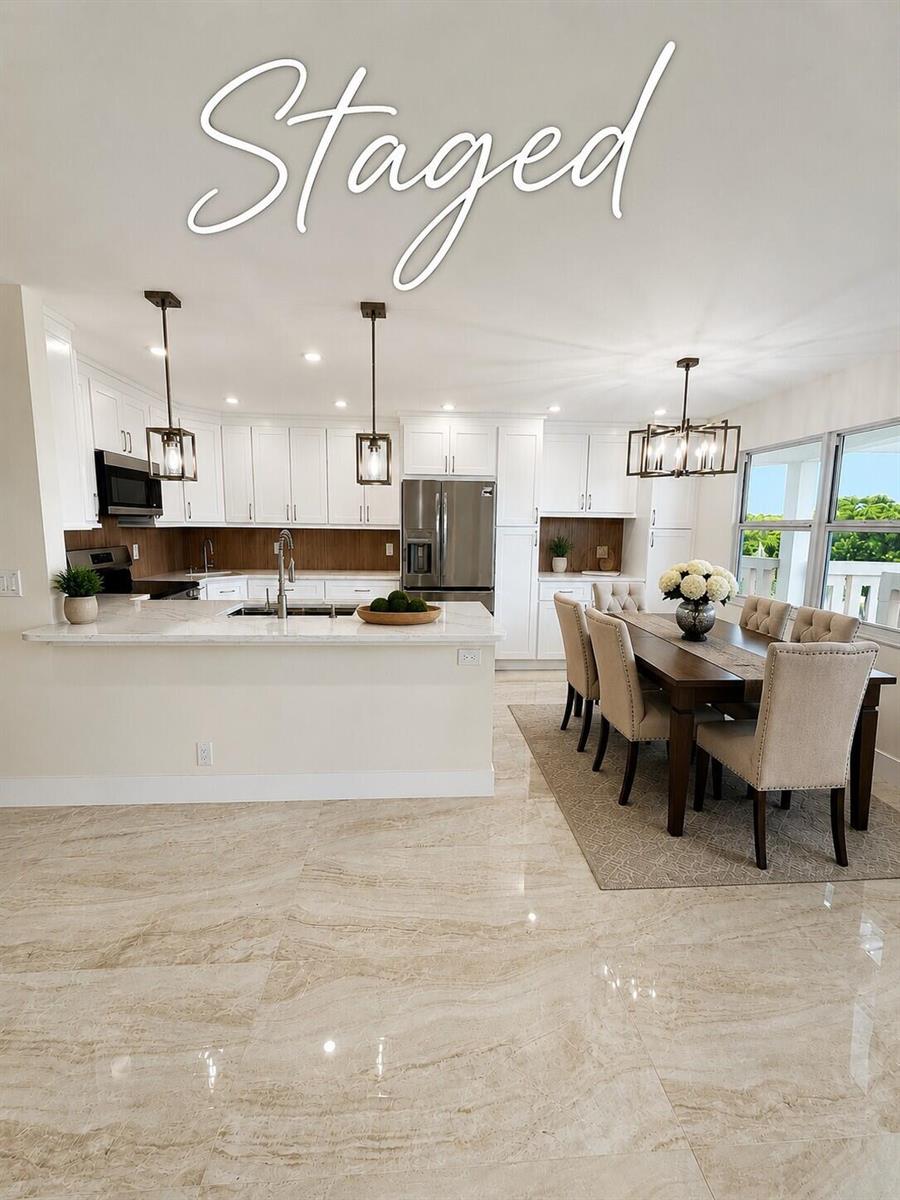 A kitchen and dining area with white cabinets, marble countertops, and large beige floor tiles — 4047 Ainslie C # 4047, Boca Raton FL 33434, BOCA RATON, FL