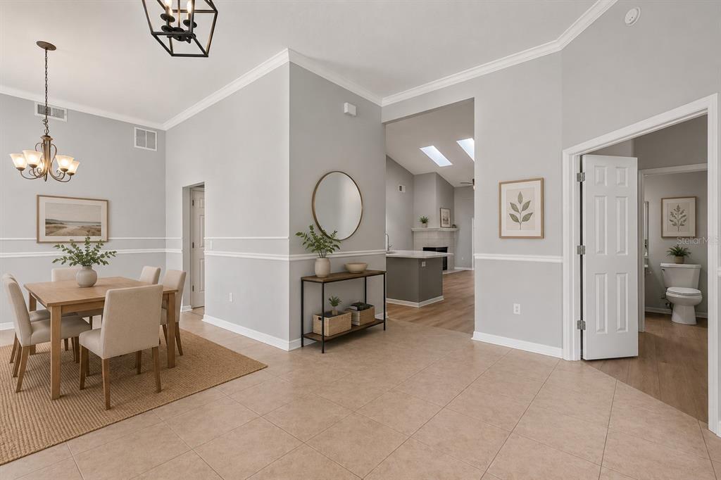A dining area with a table and chairs sits next to a hallway and bathroom — 623 YORKSHIRE DRIVE, OVIEDO, FL