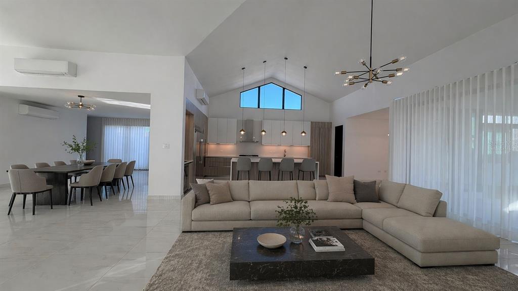 A spacious open-concept living area features a vaulted ceiling, modern kitchen, and dining space — 927 SABANERA ISLA NORTE, DORADO, PR