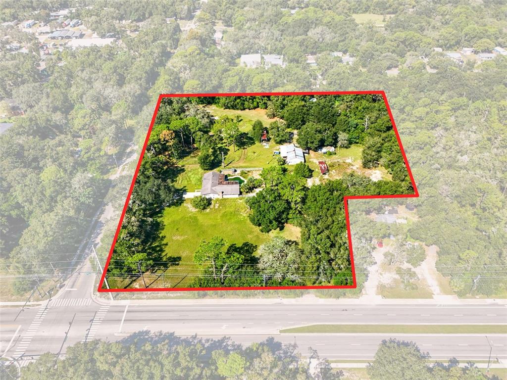 An aerial view shows a house and outbuildings on a large, tree-filled lot — 51 E PONKAN ROAD, APOPKA, FL